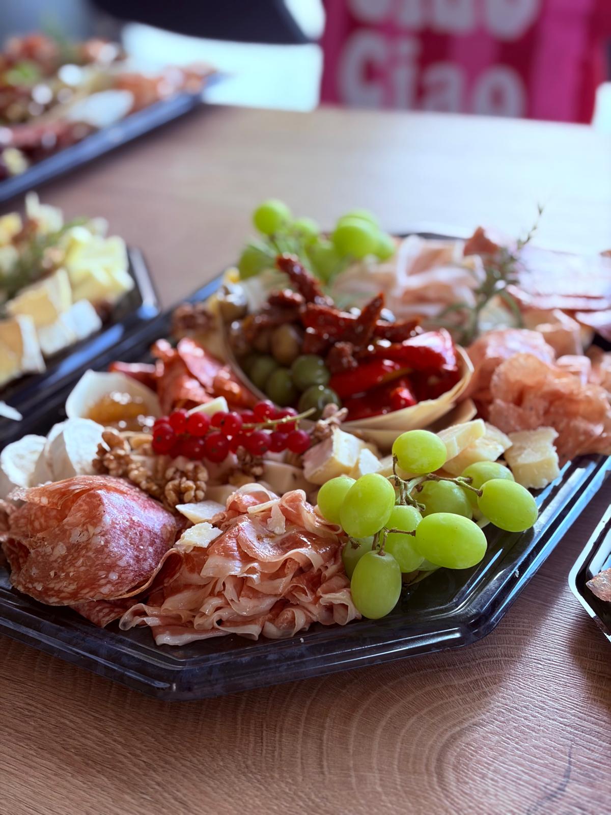 Antipastiplatte mit Schinken, Salami, Käse und Trauben im Detail
